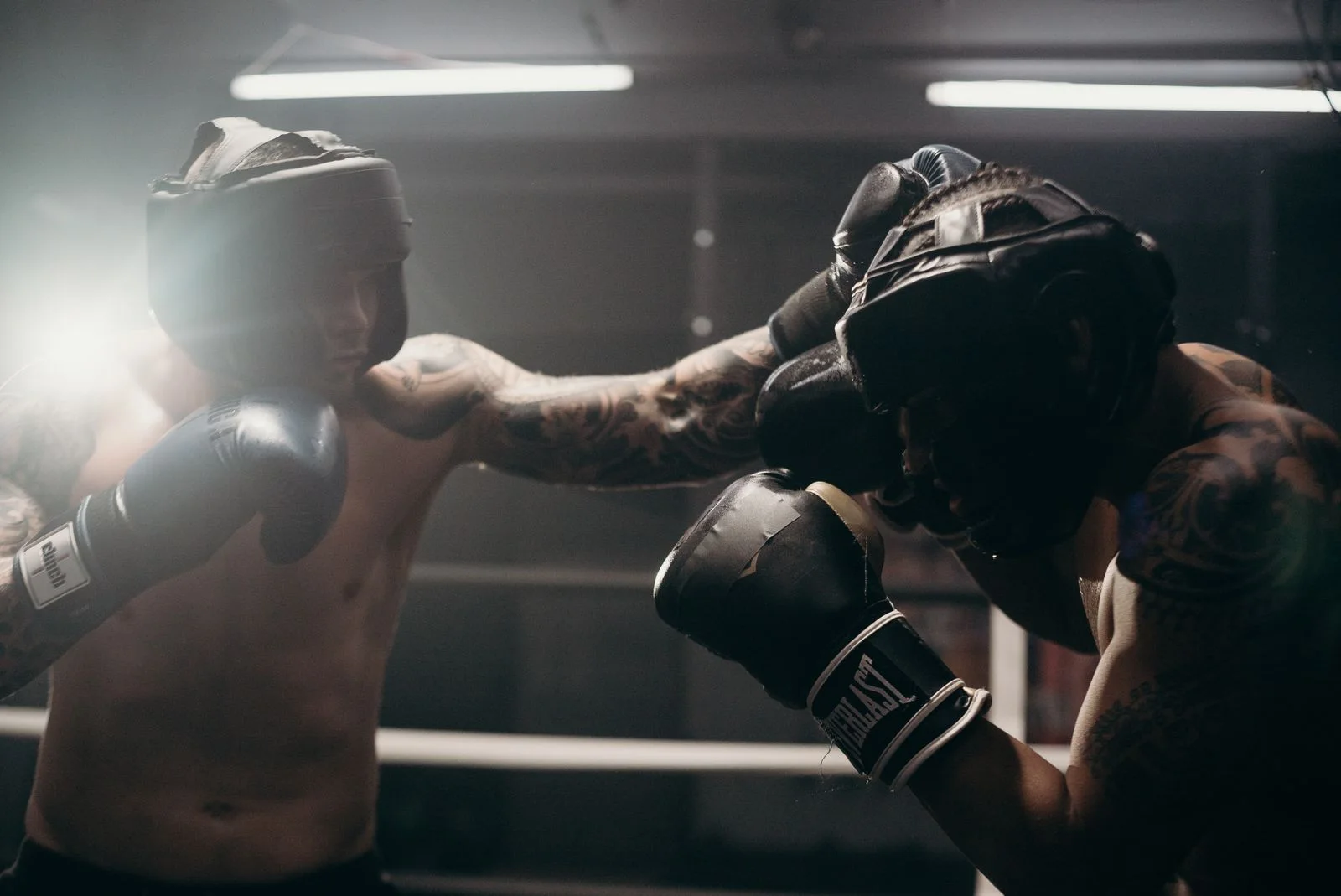 Two adults training with boxing gloves in a gym